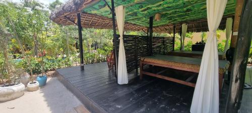 a wooden deck with a bed and an umbrella at Salama & Mbuyuni Bungalows in Matemwe