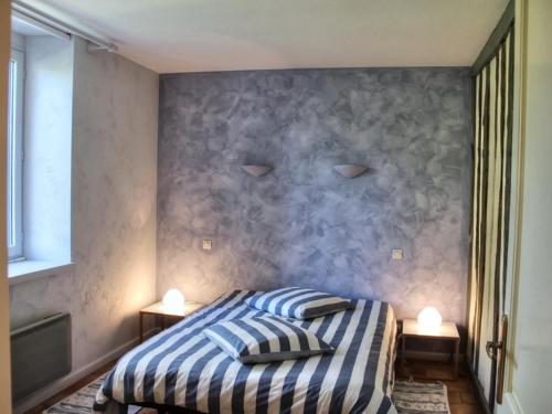 ein Schlafzimmer mit einem Bett mit zwei Kissen darauf in der Unterkunft Gîte Cheillé, 3 pièces, 4 personnes - FR-1-381-68 in Cheillé