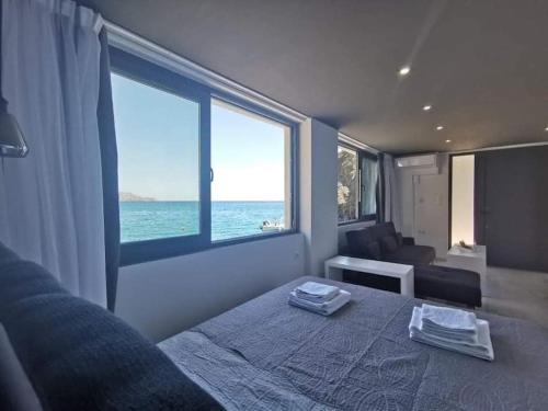 a bedroom with a bed with a view of the ocean at Sunrise Luxury Seaside Apartment in Paránimfoi