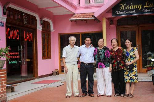 een groep mensen die voor een roze gebouw staan bij Hoang Lan Hostel in Sa Pa