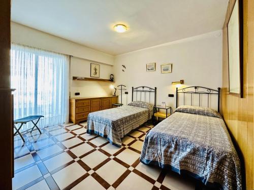 a bedroom with two beds and a tiled floor at Passeig CostaBravaSi in Sant Feliu de Guíxols