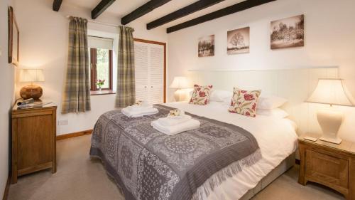 a bedroom with a bed with two towels on it at The Haven in Norham