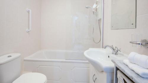 a white bathroom with a toilet and a sink at The Haven in Norham