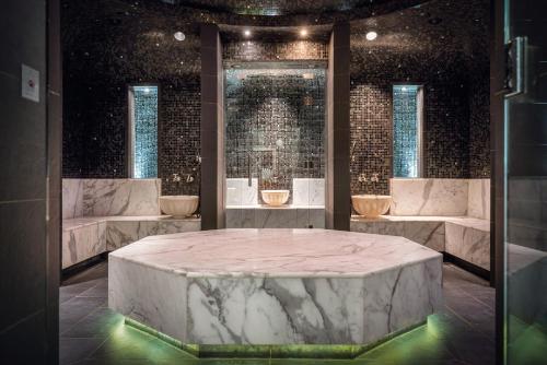 Cette chambre dispose d'une grande table en marbre et de fenêtres. dans l'établissement Elite Hotel Marina Tower, Spa & Resort, à Stockholm