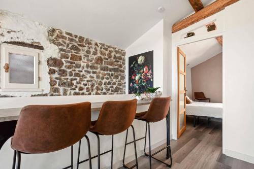 eine Küche mit einer Steinmauer und 3 Stühlen in der Unterkunft Maison de ville Fréjus in Fréjus