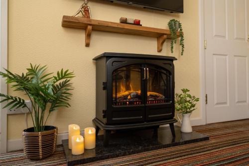 a fireplace in a living room with candles on the floor at Belmont House Beer - Adults Only - Free Parking in Beer