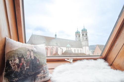 a pillow sitting in a window with a church at NEU Deluxe Suite Münsterblick, Maisonette, Kingsize Bett, Küche, Netflix, Aussicht, E-Kamin in Bad Säckingen