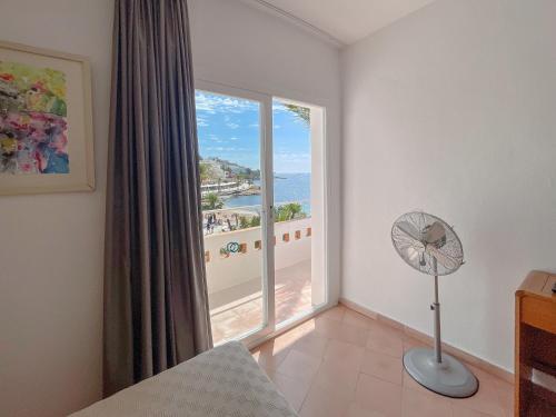 Habitación con ventilador y ventana grande. en Hotel Figueretes, en Ibiza