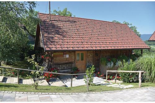 una pequeña casa de madera con techo rojo en Homestead Bahor With Whirlpool - Happy Rentals, en Črnomelj