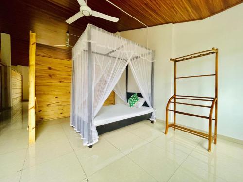 a bedroom with a bed with a mosquito net at JP Hostels & Apartment in Kandy