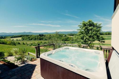 un jacuzzi en un patio con vistas en Homestead Bahor With Whirlpool - Happy Rentals, en Črnomelj