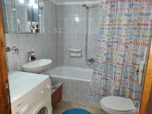 ein Badezimmer mit einer Badewanne, einem WC und einem Waschbecken in der Unterkunft Marie claire home -Private parking in Thessaloniki