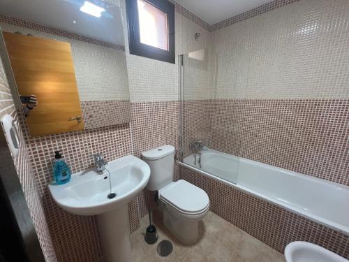 uma casa de banho com um WC, um lavatório e uma banheira em Apartamento entero con terraza y piscina em Águilas