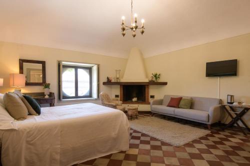 a bedroom with a bed and a couch and a television at Tenuta del Gelso in Catania