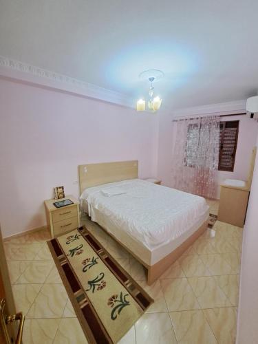 Un dormitorio con una cama grande y una ventana en Apartament Miraka en Gramsh