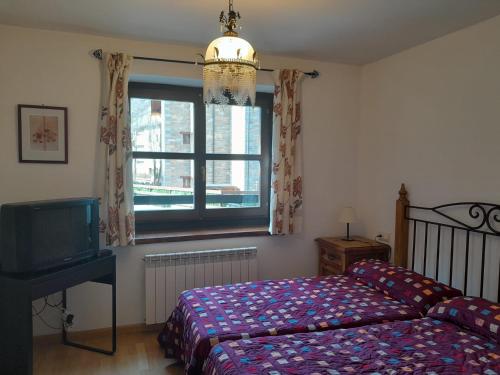 - une chambre avec un lit, une télévision et une fenêtre dans l'établissement Apartamento Nevados 19101, à Anciles