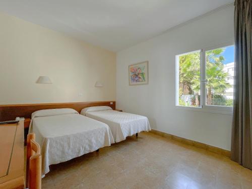 a hospital room with two beds and a window at Hotel Figueretes in Ibiza Town