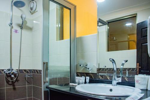 a bathroom with a sink and a mirror at Bomah Hotel Limited in Gulu