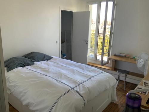 - une chambre avec un lit et une porte donnant sur un balcon dans l'établissement Montmartre, à Paris