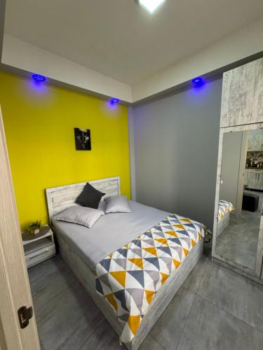 ein Schlafzimmer mit einem Bett und einer gelben Wand in der Unterkunft Comfy Apartment with a Spacious Balcony Self Check In in Yerevan