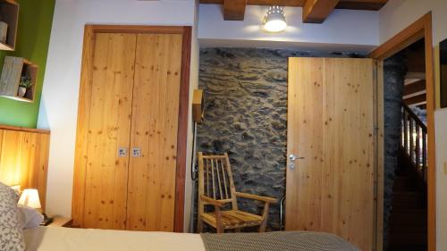 a bedroom with a bed and a stone wall at Cal Batlle Casa Rural in La Cortinada