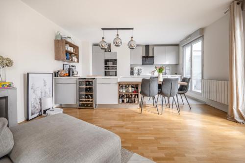 un salon avec une table et des chaises et une cuisine dans l'établissement Charming Terrace Apt Near Paris - Olympics, aux Lilas