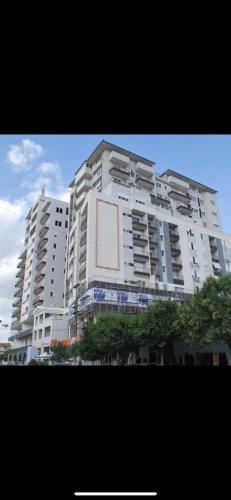 een groot wit gebouw met een bord erop bij 12th floor one bed apartment in Elbasan