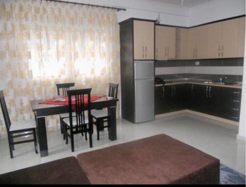 een keuken met een tafel en stoelen in een kamer bij 12th floor one bed apartment in Elbasan
