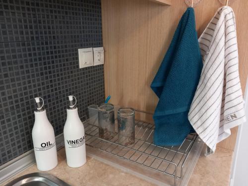 two bottles on a rack next to a sink in a bathroom at Sapphire apartment in Agios Nikolaos