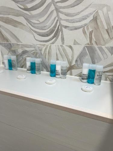 una fila de botellas de odorizantes en un mostrador en un baño en Exyca Metropolitano, en Madrid