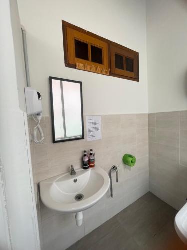 a bathroom with a sink and a mirror at The Grand Bali Hotel in Malacca