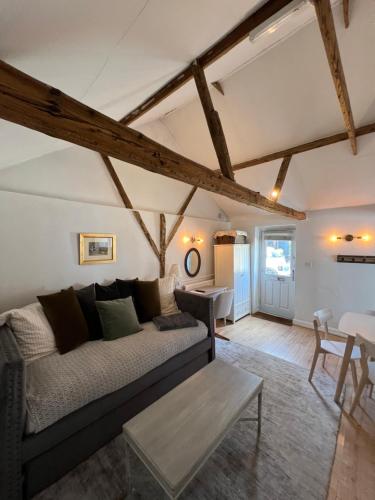 Pear & Olive Cottage في Hildersham: غرفة معيشة مع أريكة وطاولة