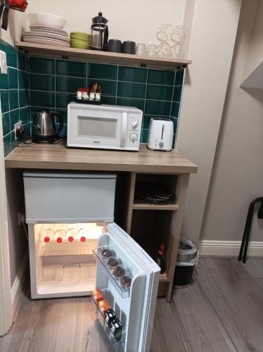 a small kitchen with a microwave on a counter at Tom Dick and Harriet's Accommodation in Dublin