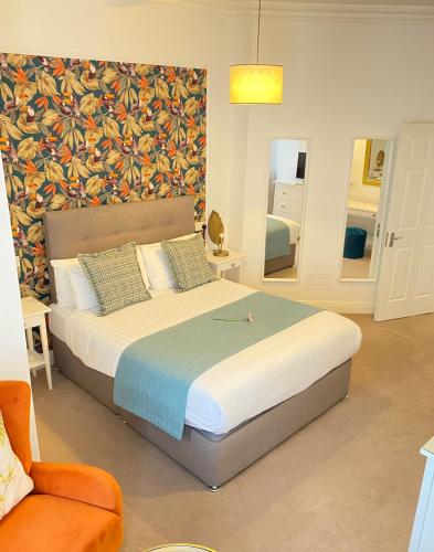 a bedroom with a large bed and a chair at Tom Dick and Harriet's Accommodation in Dublin