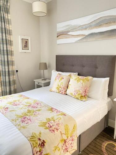a bedroom with a bed with flowers on it at Tom Dick and Harriet's Accommodation in Dublin