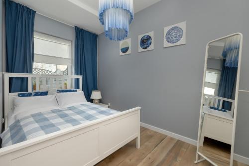 a bedroom with a white bed and blue curtains at Stylish Apartment Grunwaldzka by Rent like home in Świnoujście