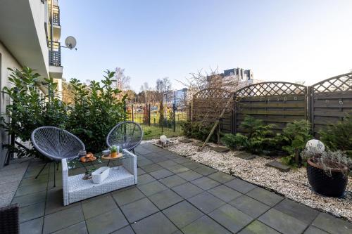 a small garden with two chairs and a table at Stylish Apartment Grunwaldzka by Rent like home in Świnoujście