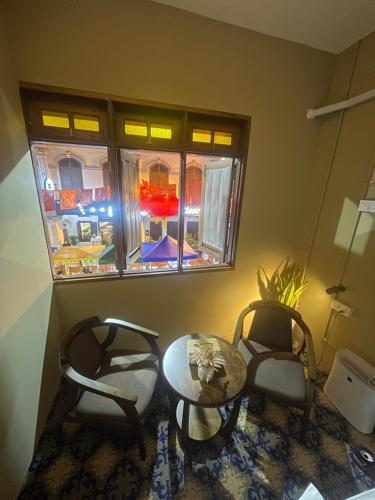 a room with two chairs and a table and a window at The Grand Bali Hotel in Malacca