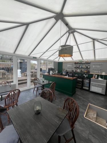 um restaurante com mesa e cadeiras e um balcão em Pear & Olive Cottage em Hildersham