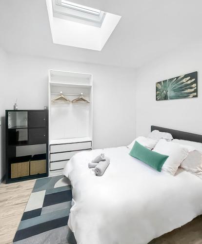 - une chambre dotée d'un lit blanc avec un ours en peluche dans l'établissement Perle de la Loire, à Blois