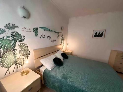 a bedroom with a green bed with a plant on the wall at Bay view Appartment in Paceville
