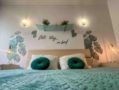 una camera da letto con un letto con cuscini verdi di Bay view Appartment a Paceville