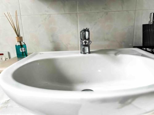 Un lavabo blanco con grifo en un baño. en Bay view Appartment, en Paceville