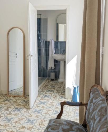 a bathroom with a sink and a mirror and a chair at Le Couvent des Ecrevisses in Barjols