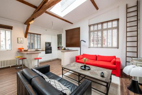 un salon avec un canapé rouge et une table dans l'établissement Paris 9ème - Superbe loft avec terrasse privative, à Paris