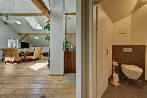 a bathroom with a toilet and a dining room at Ferienwohnung Rupp in Sibratshofen