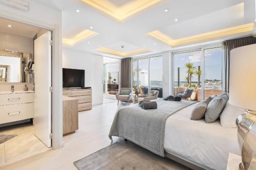 a bedroom with a large bed and a living room at Phenthouse Monaco - Jacuzzi - City Center - Sea View in Albufeira