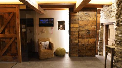 a living room with a wooden door and a chair at Cal Batlle Casa Rural in La Cortinada