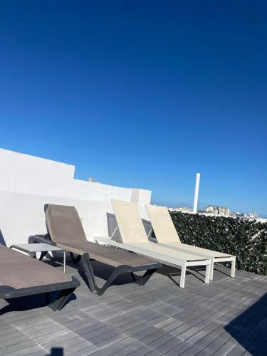 a group of lounge chairs sitting on a patio at Beautiful 3BR Triplex penthouse with Hot-Tub by 360 Estates in Il-Gżira