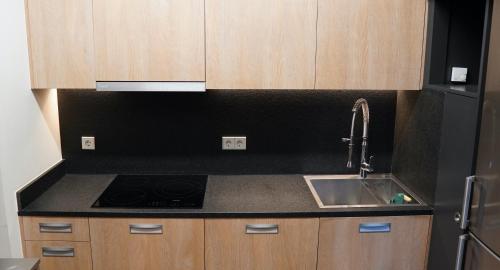 a kitchen with a sink and a stove at Cal Batlle Casa Rural in La Cortinada
